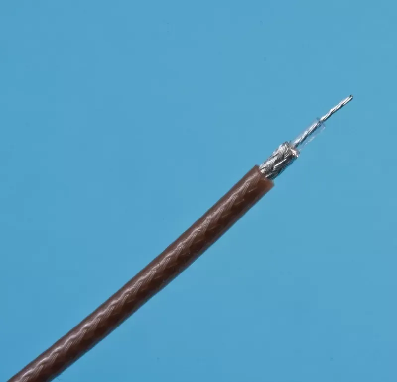 A brown coaxial cable with its outer insulation stripped back to reveal the internal braided shield and inner wire.