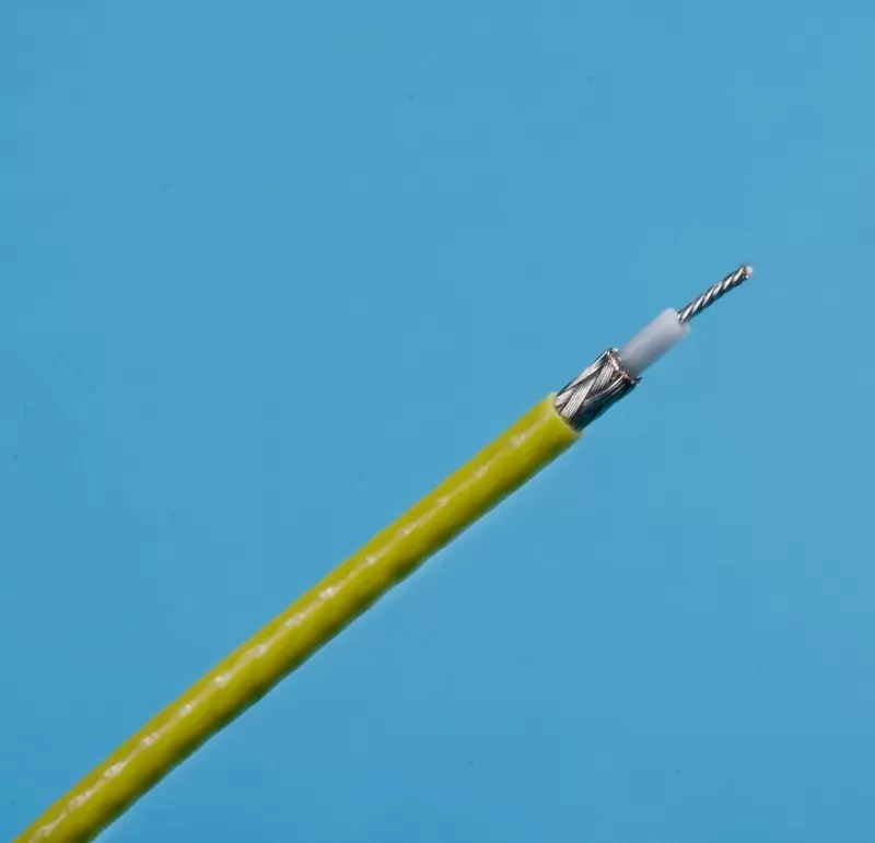 A stripped yellow coaxial cable showing its inner metallic braiding, white dielectric insulation, and central wire.