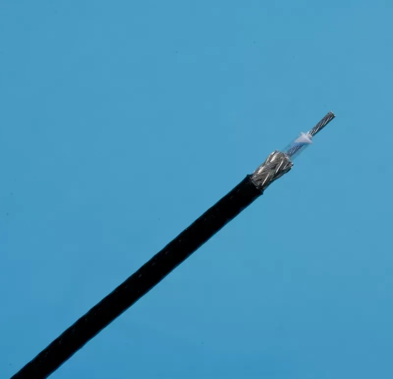 A close-up view of a stripped coaxial cable against a bright blue background, showing the metal mesh and inner conductor.