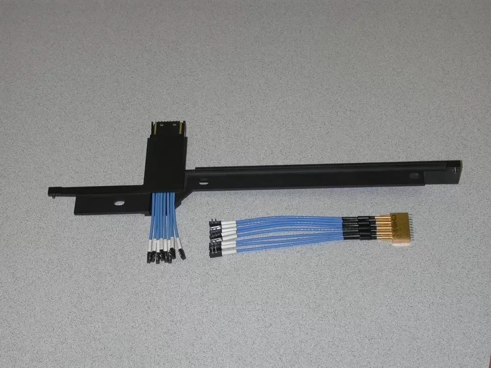A black mounting bracket with blue wiring, one end with individual pins and the other with a gold-plated multi-pin plug.