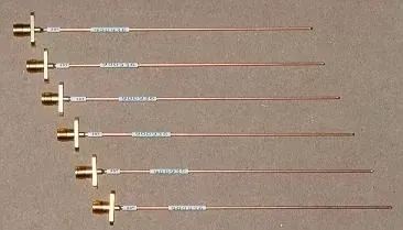 Six coaxial cable antennas of varying lengths arranged vertically, each with a gold-colored SMA connector at one end.