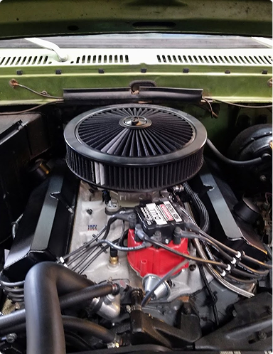 Classic car engine bay with a large black air filter and red engine block.  | Hudson Automotive