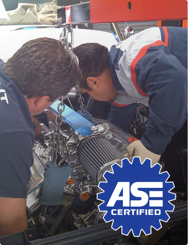Two mechanics inspecting an engine in a garage with an ASE Certified logo  | Hudson Automotive