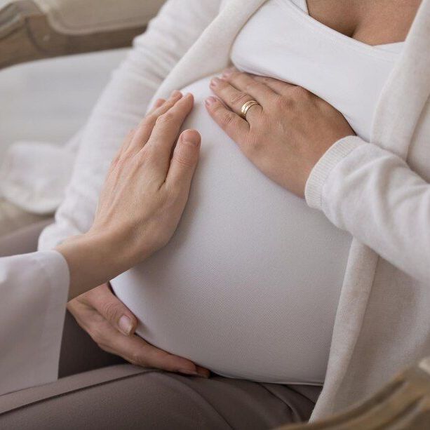 A pregnant woman is being examined by a doctor.