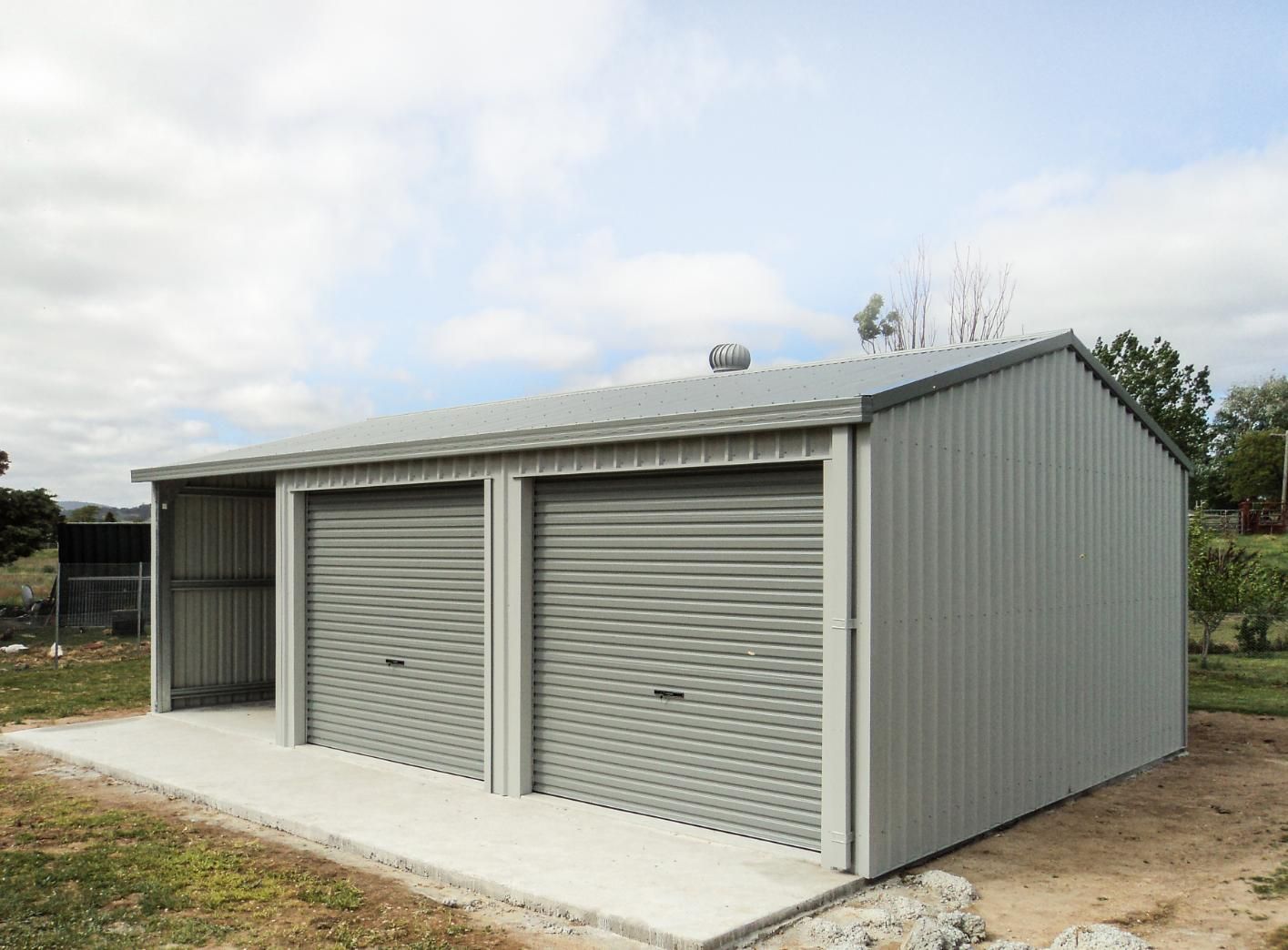A Garage with Two Garage Doors and A Shed in The Backyard — Clearspan Builders In Queanbeyan East, NSW