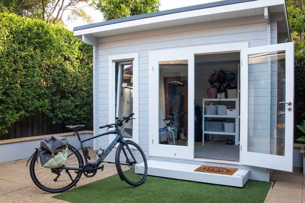 A Bicycle Is Parked In Front Of A Small White House — Clearspan Builders In Queanbeyan East, NSW