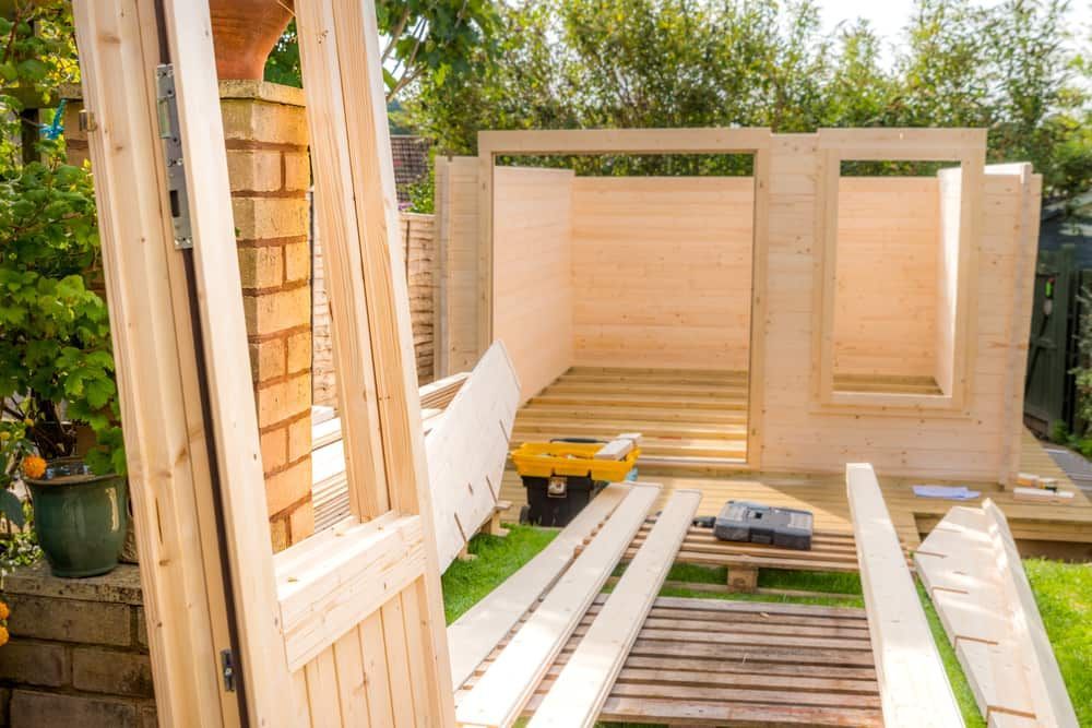 Wooden Shed Under Construction in a Backyard; Lumber and Tools Scattered on Grass — Clearspan Builders In Bungendore, NSW