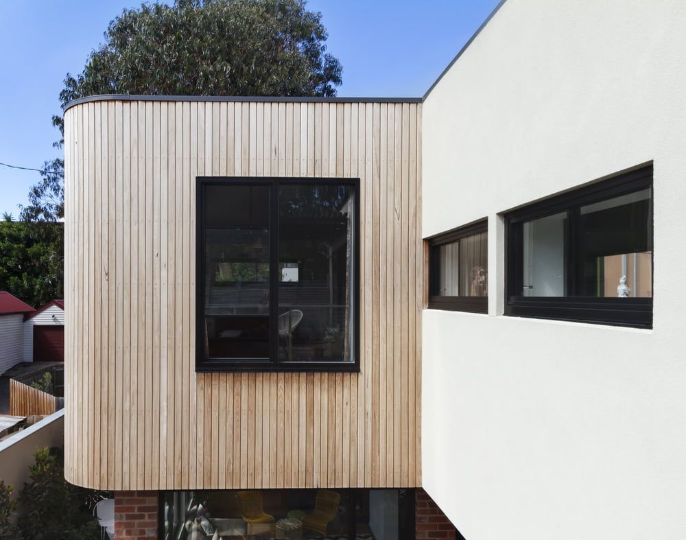 Modern House Exterior With Wood Siding and Black-framed Windows — Clearspan Builders In Royalla, NSW