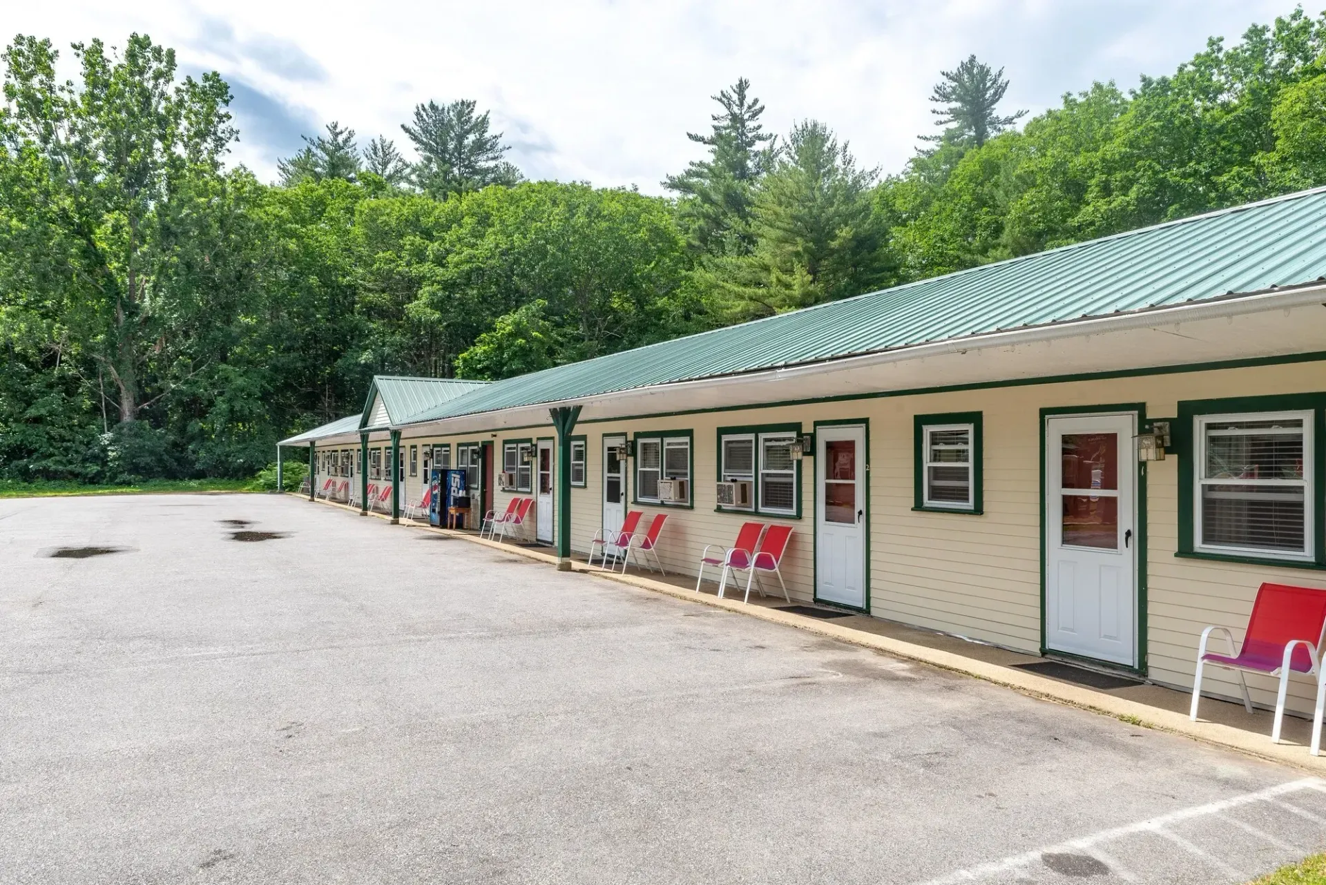 A motel with a parking lot in front of it