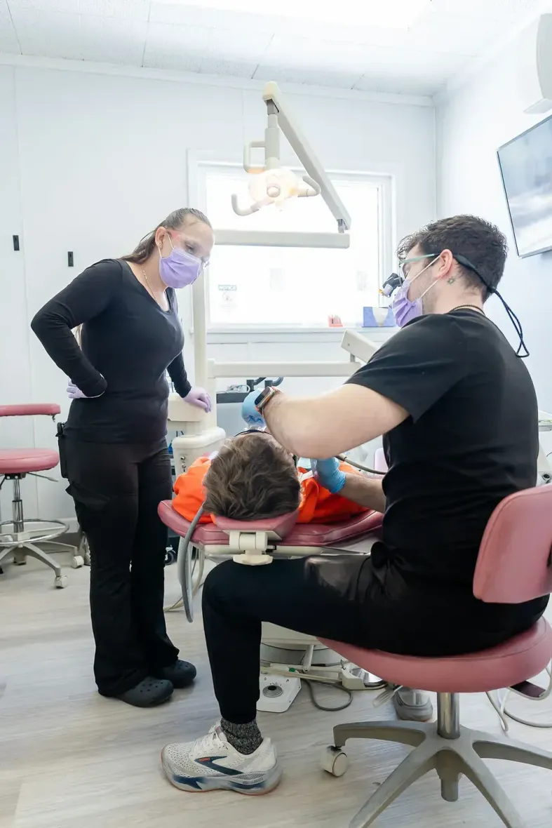 Dentist and assistant examining a patient in a bright dental clinic