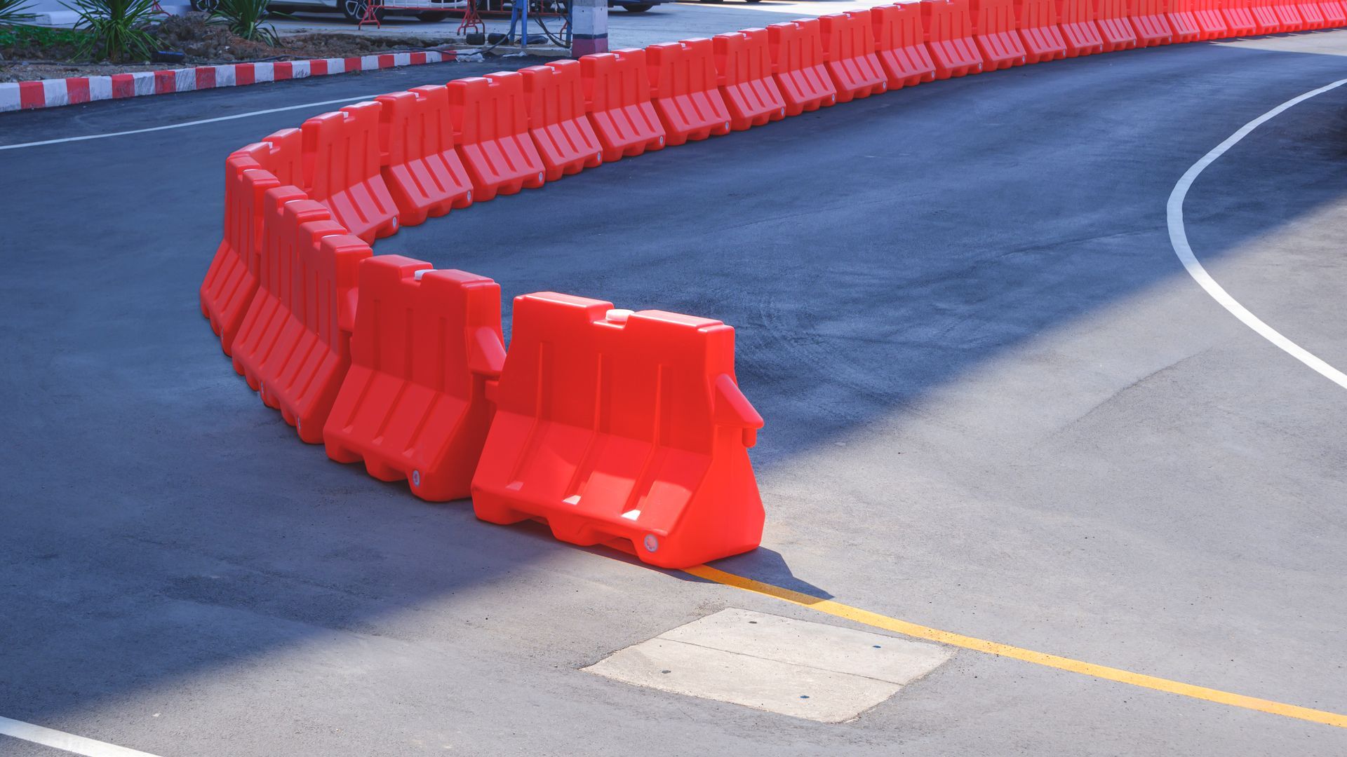 A row of red plastic barriers on the side of a road.