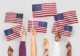 A group of people are holding american flags in their hands.