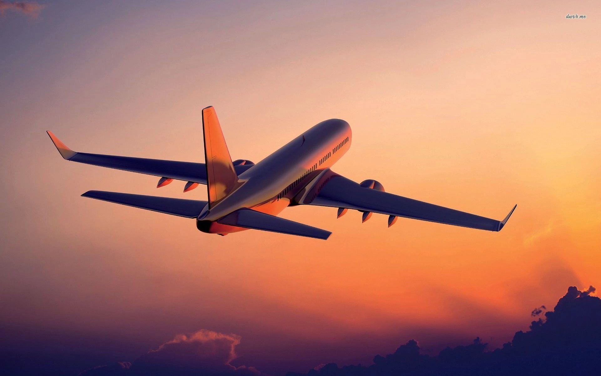 An airplane is flying in the sky at sunset.