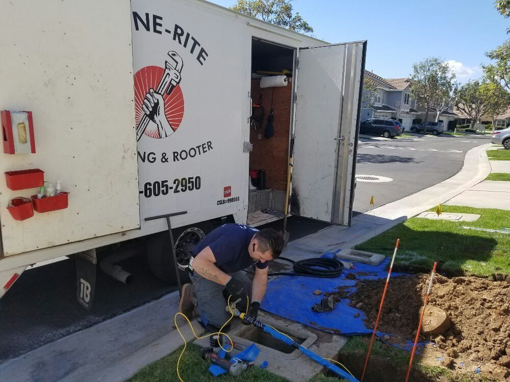 Plumber repairing a trench beside a service truck on a suburban sidewalk, with tools and blue tarp.