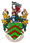 Coat of arms with a shield, crest of a red dragon holding flags, and green and red stripes.