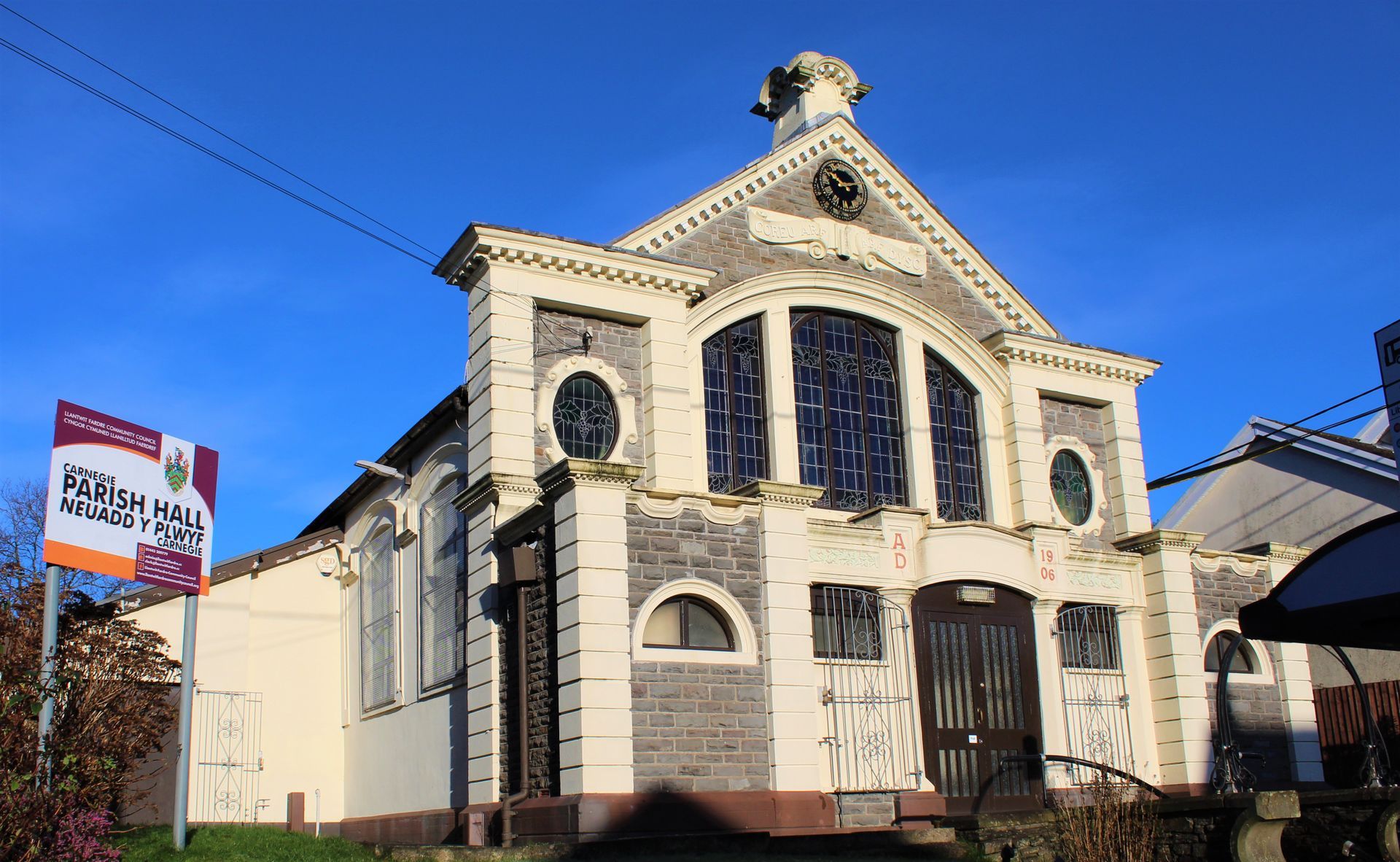 Cream-colored chapel with stained-glass windows, a sign that says 