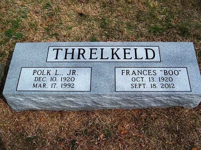 Gray granite graveside marker on grass engraved “THRELKELD” with two memorial plaques.