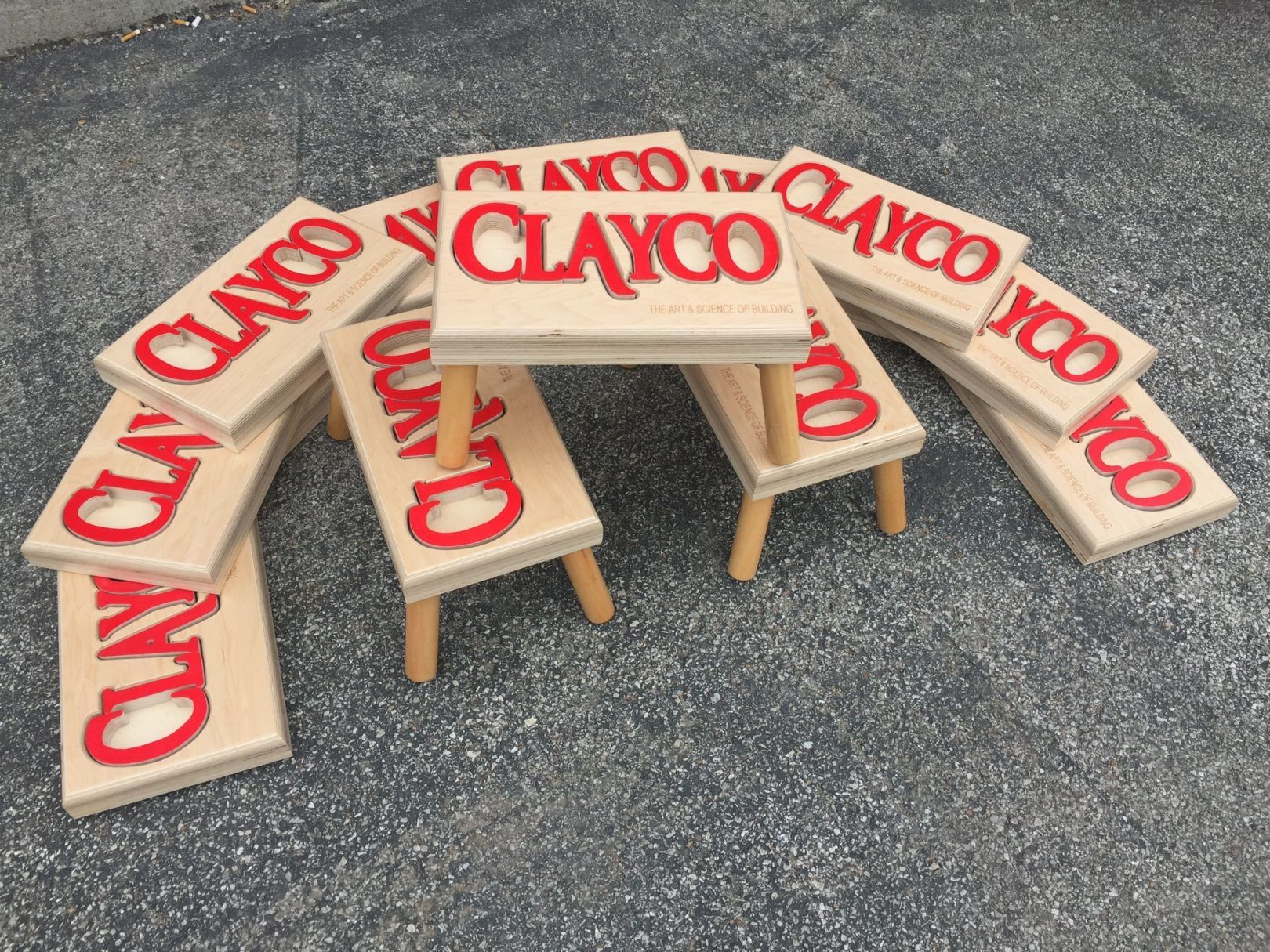 Multiple puzzle stools stacked on top of eachother with "Clayco" logo for corporate gifts.