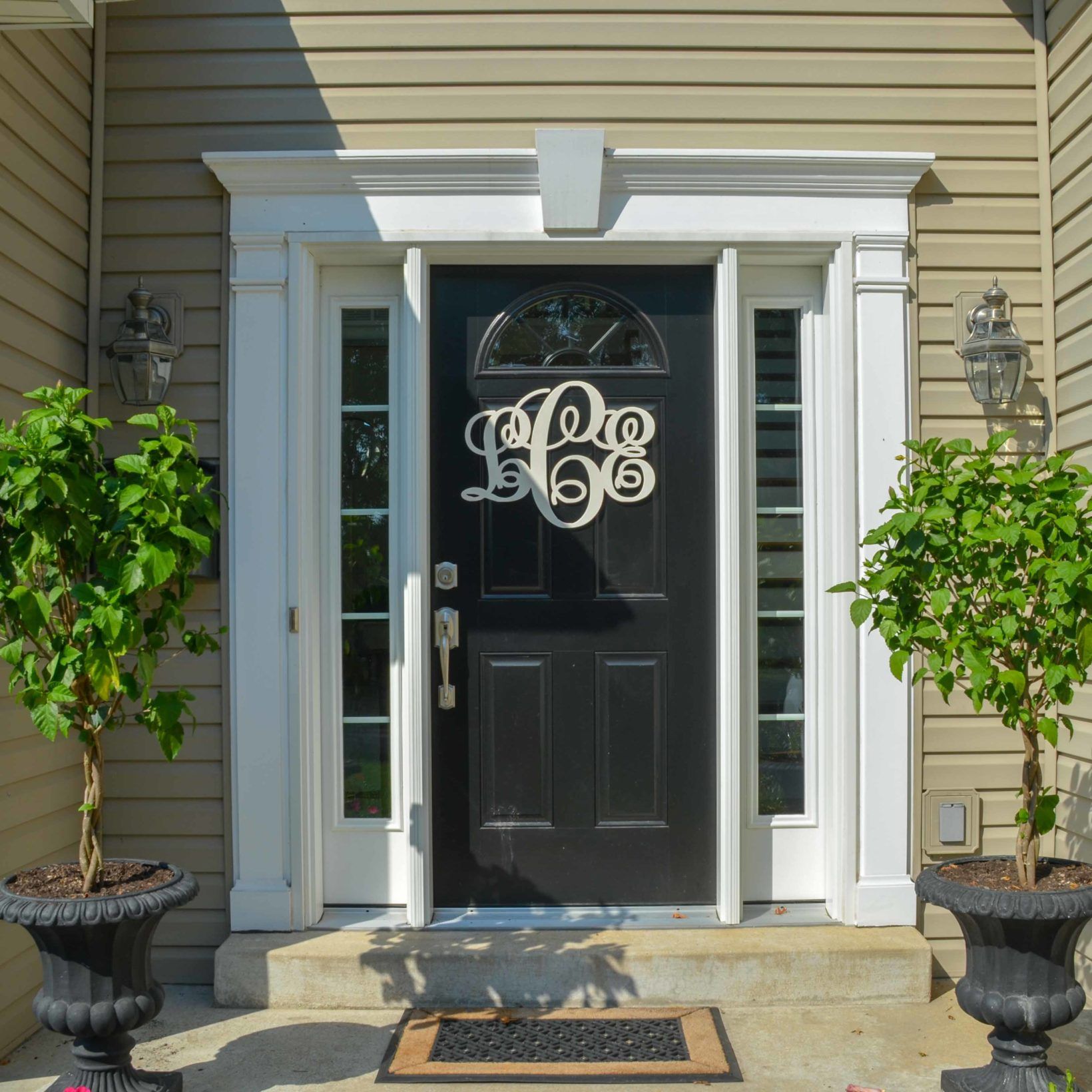 Hollow Woodworks Monogram on the front of a black door on a house. 