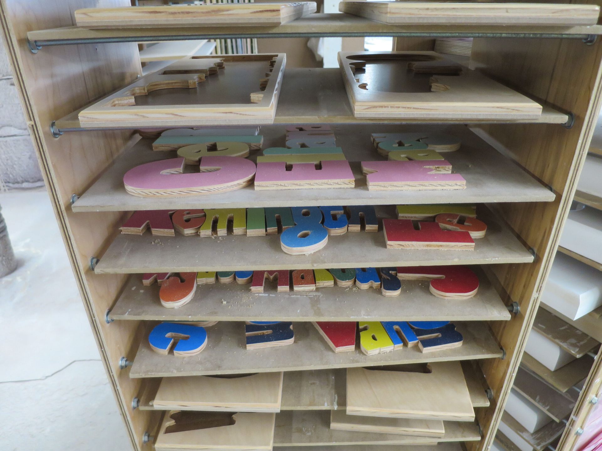 Multiple shelves showing puzzle pieces that are ready to be assembled into puzzle stools. 
