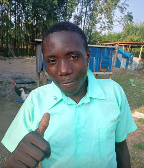 Man in light blue shirt gives thumbs up outside.