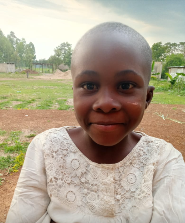 Smiling young girl in white shirt outdoors.