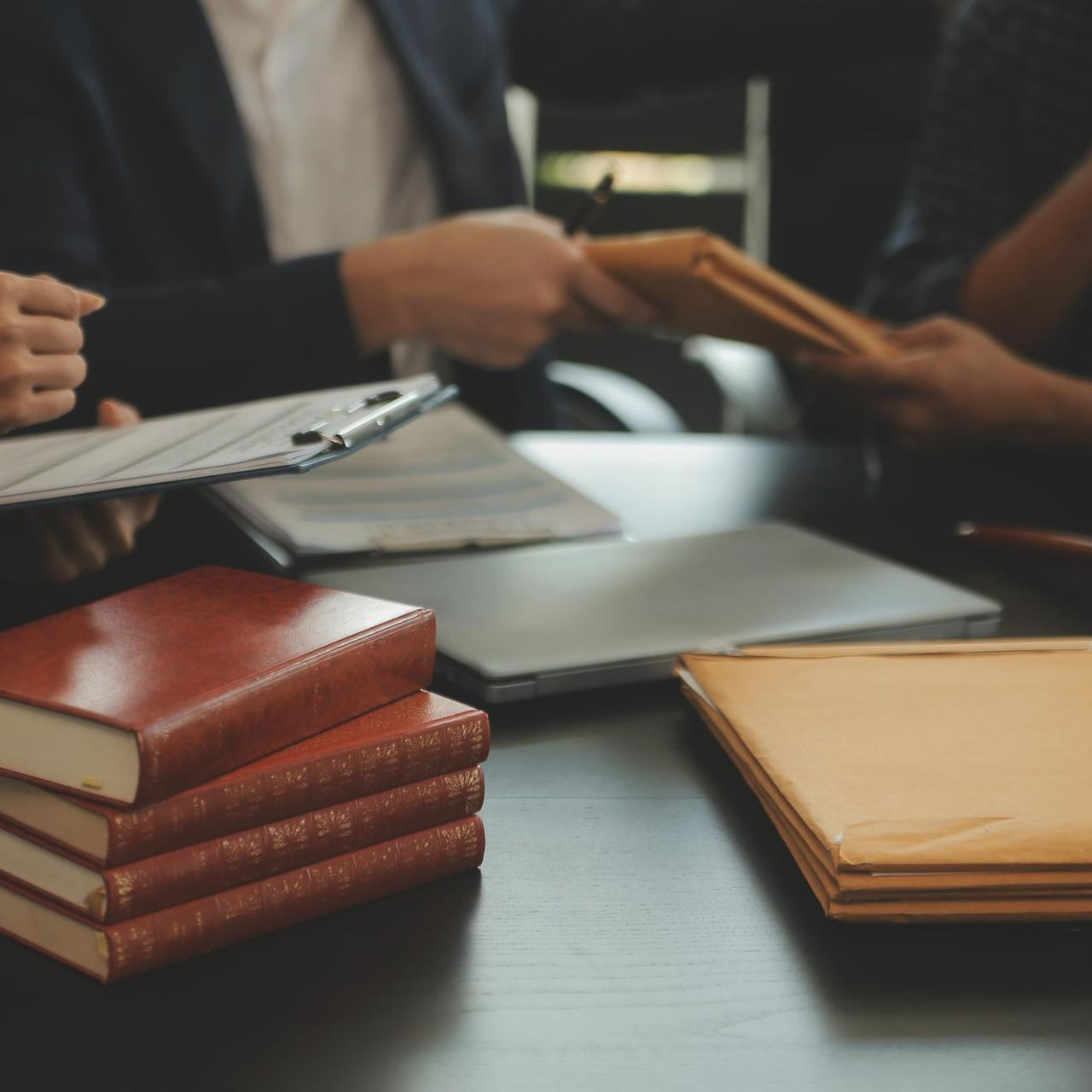 Lawyer meeting with files and books on a conference table