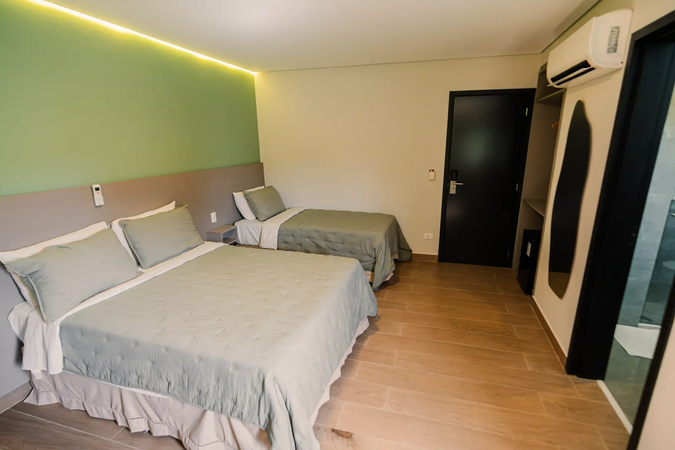 Um quarto de hotel com duas camas e um espelho hotel oly plaza