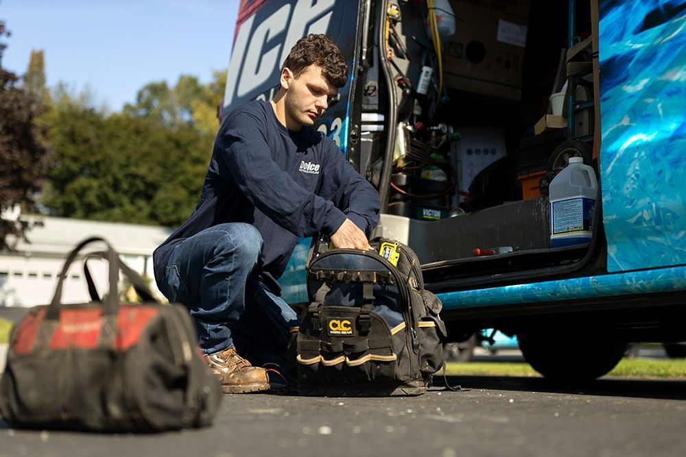 a man is kneeling next to a tool bag