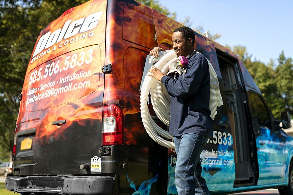 a man carrying a hose in front of a dolce van