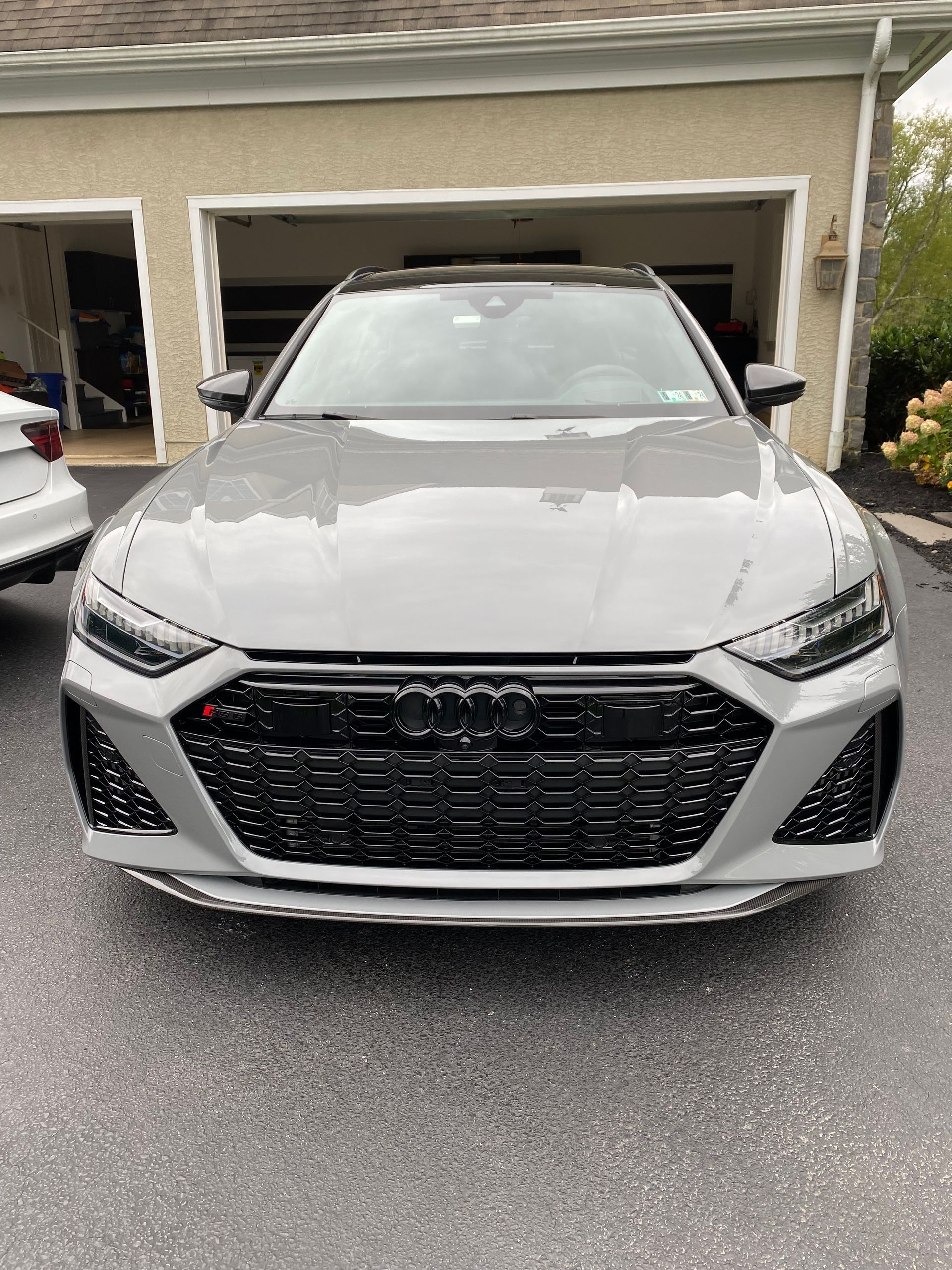 Silver Audi RS 6 Avant parked in front of a garage.