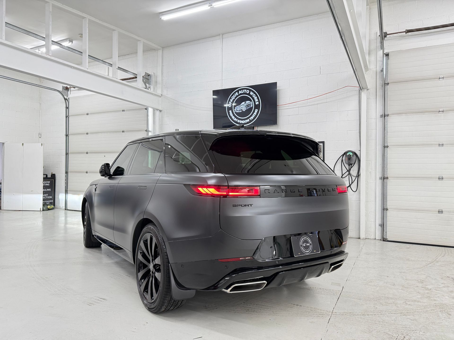 Dark gray Range Rover SUV in a bright garage.