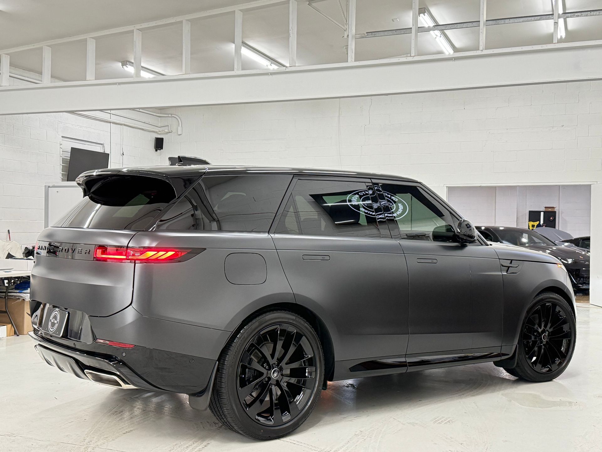 Dark gray Range Rover SUV with black rims parked in a garage.