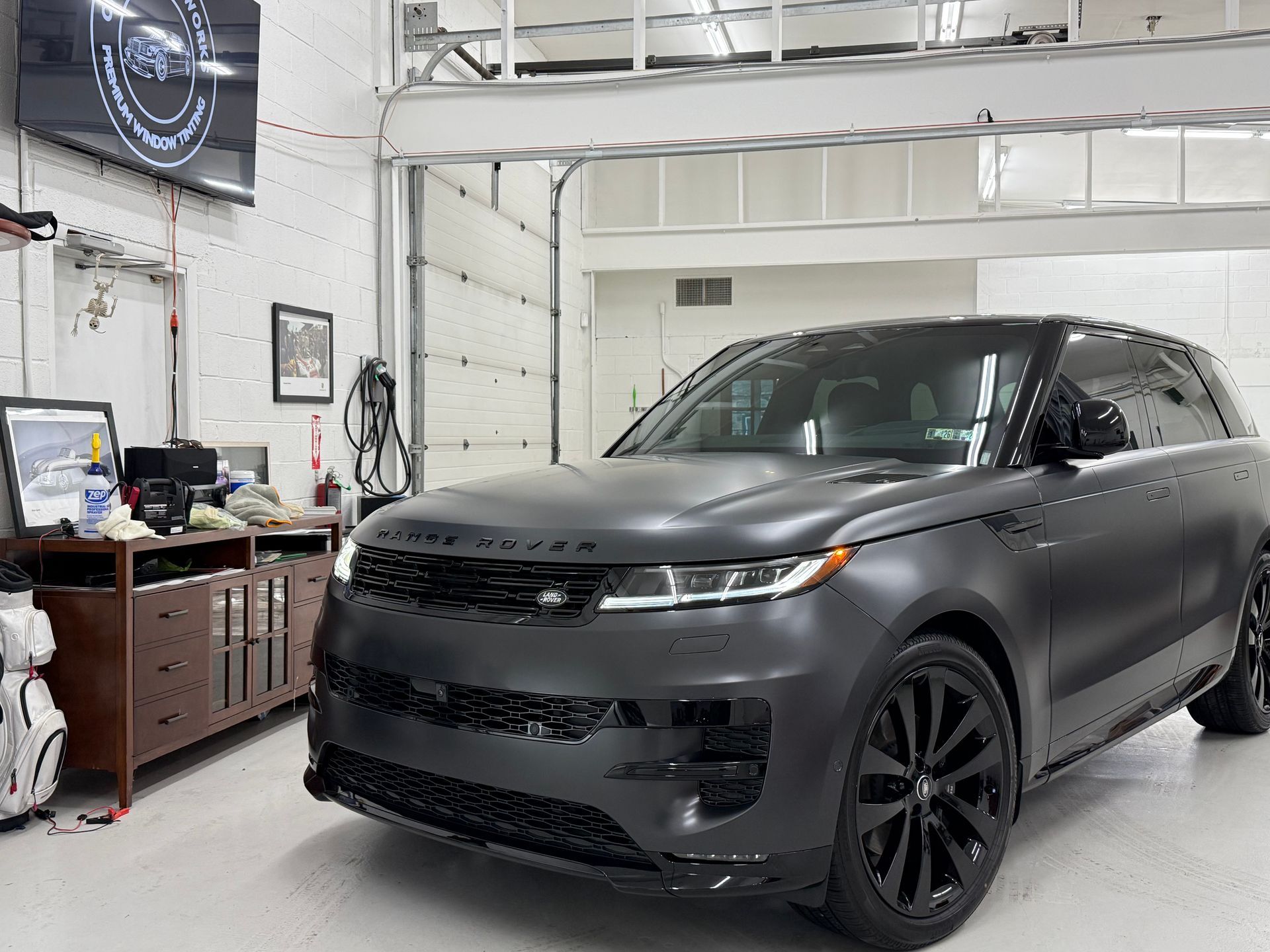 Gray matte Range Rover SUV parked inside a garage.