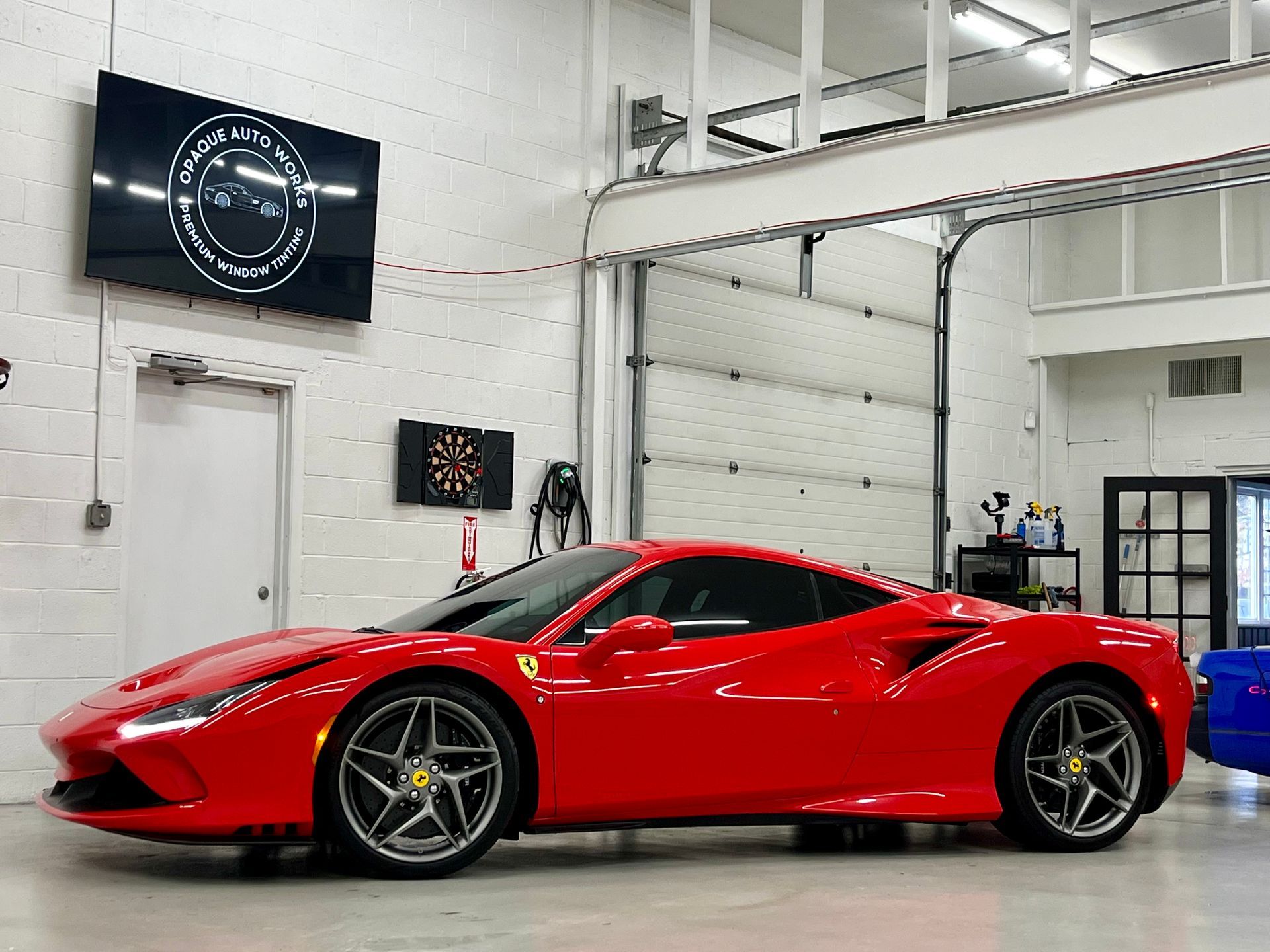 Red Ferrari sports car parked inside a garage.