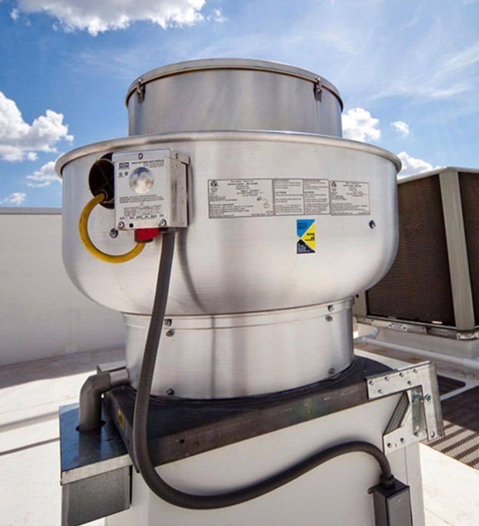 A stainless steel roof exhaust fan with a yellow and blue triangle on it