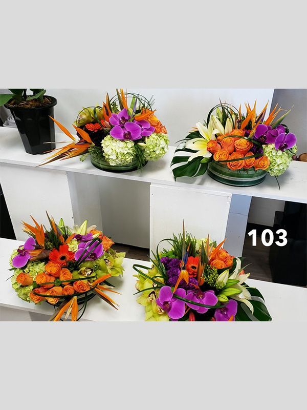 Three vases filled with flowers are sitting on a table.