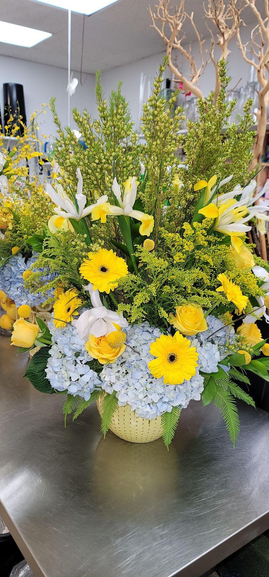 A vase filled with yellow and blue flowers is sitting on a table.