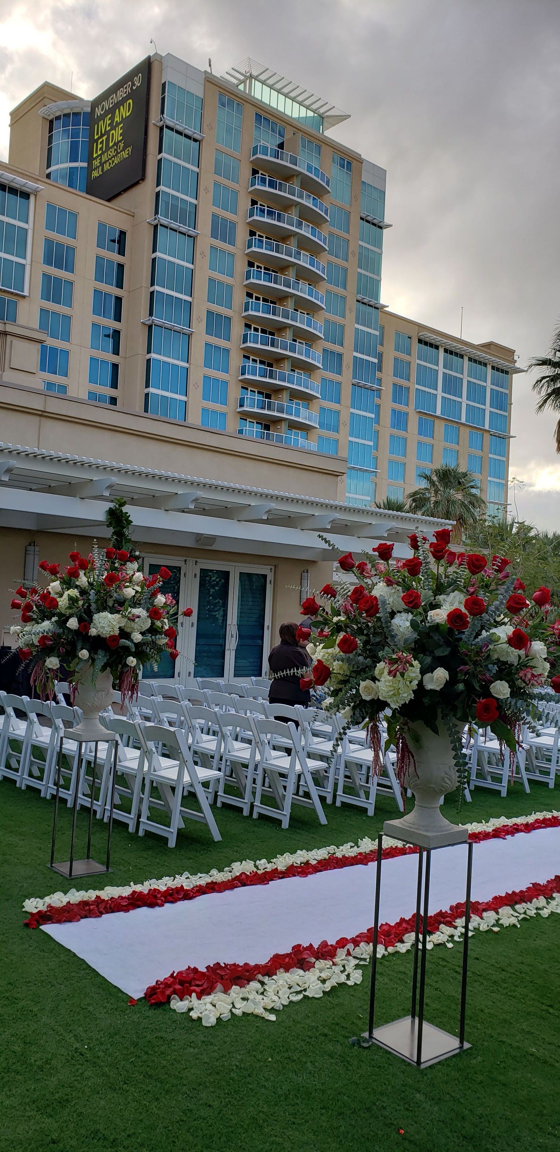 A wedding ceremony is taking place in front of a large building.
