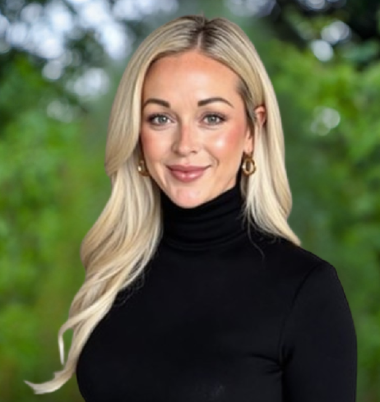 A professional headshot of a woman with long blonde hair, wearing a black turtleneck against a blurred green background.