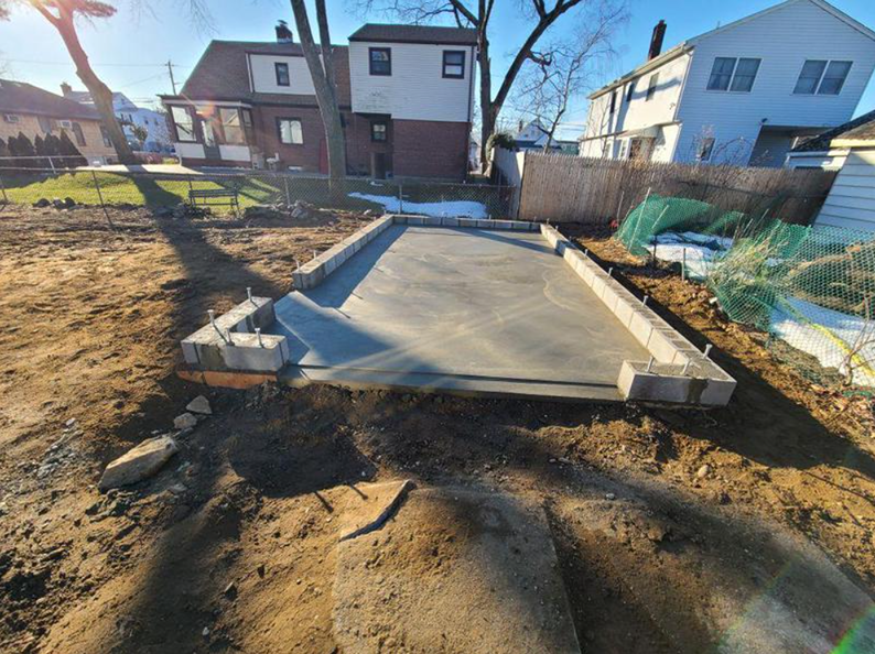 Concrete slab construction with cinder block walls in a yard.