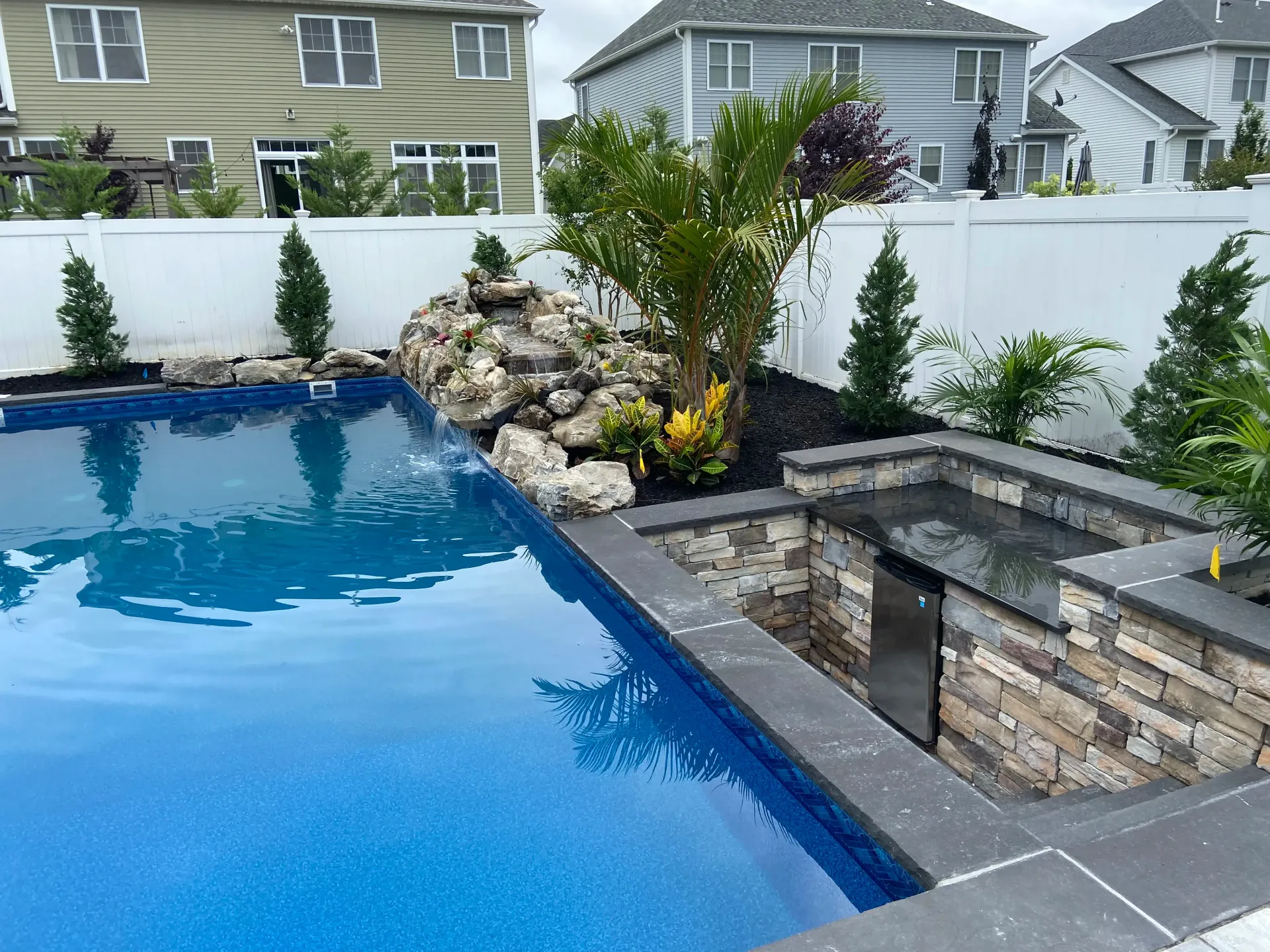 Swimming pool with waterfall and landscaping.