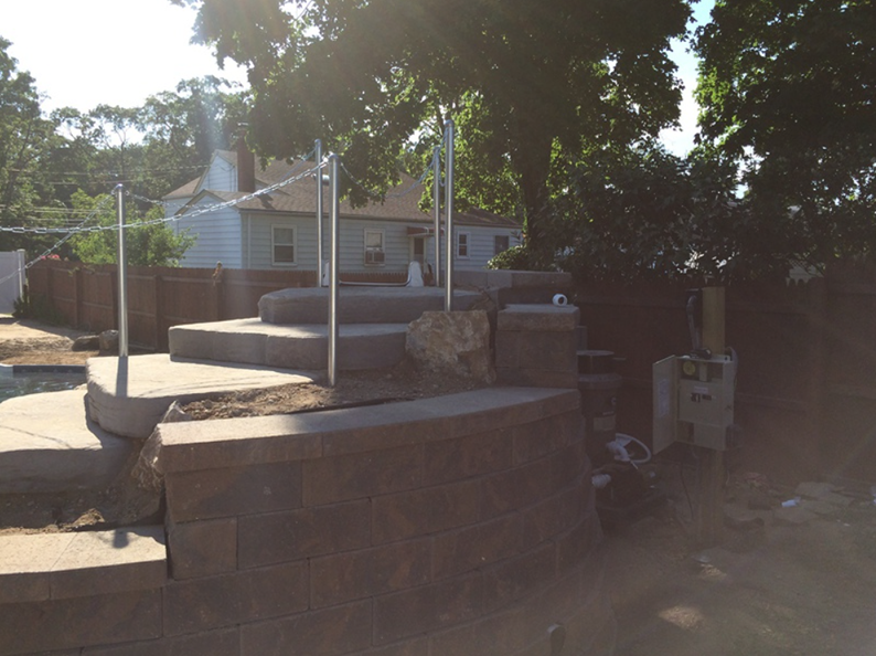 Stone steps with metal railings and a house in the background.