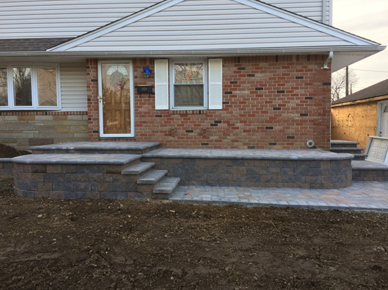 Brick house with new brick and stone porch, steps, and retaining wall.