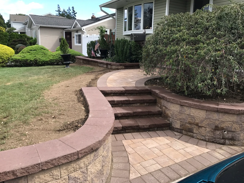 Stone path and steps leading to a house, with retaining walls and landscaping.