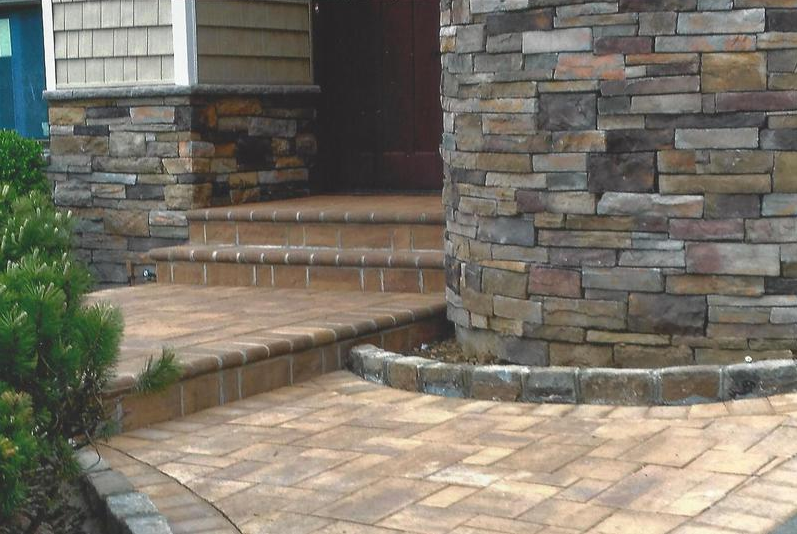 Stone entrance with steps and curved walkway.