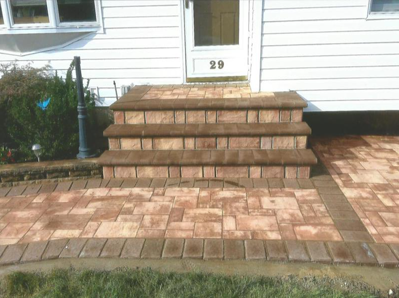 Brick steps leading to a white door with the number 29. Brick walkway with a matching border.
