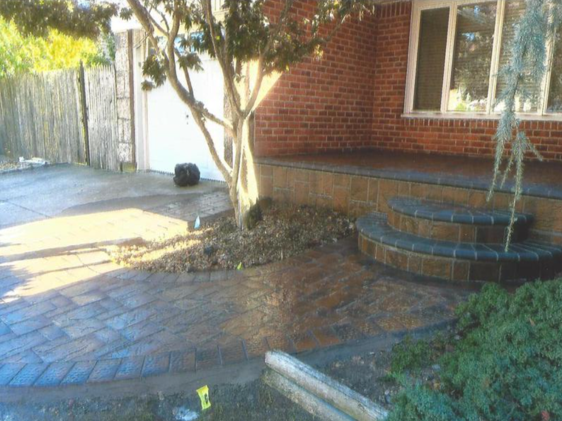 Brick home with paved walkway, small steps and tree.