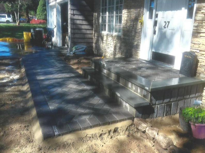 New brick pathway and steps leading to the front door of a house, with the number 27 visible.