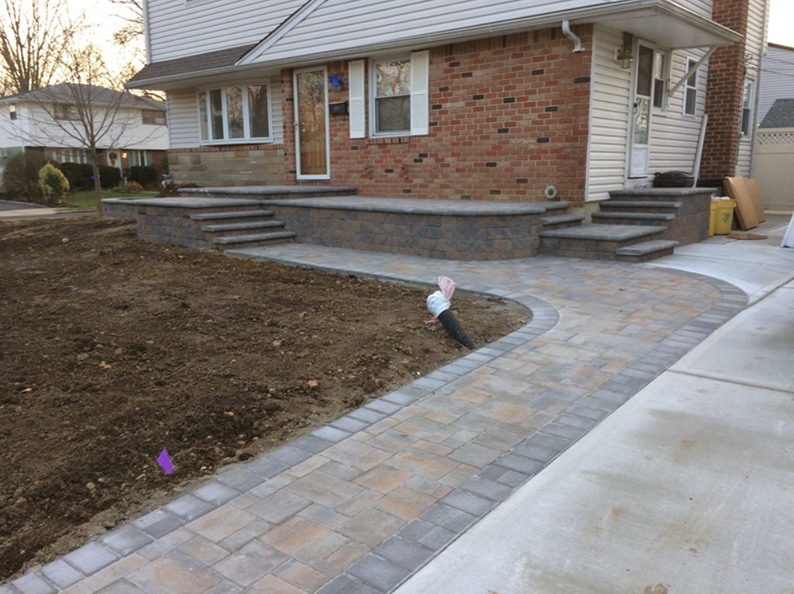 Brick home with a paved walkway and steps. The lawn is unfinished.